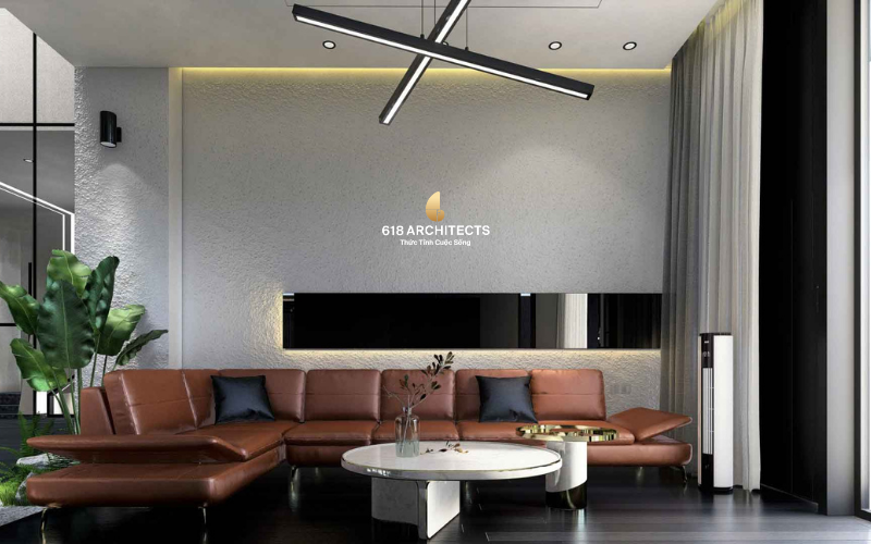 Phòng khách biệt thự Hòa Xuân với sofa da nâu và gam màu trung tính sang trọng.